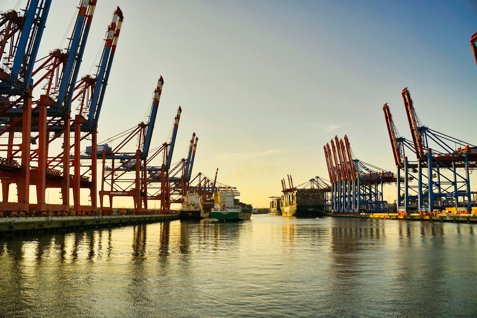 Container cranes along a harbour at dusk