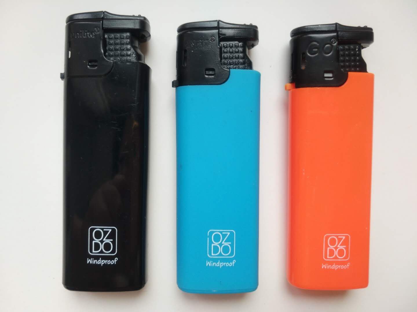 Three Ozdo windproof lighters in black, blue and orange